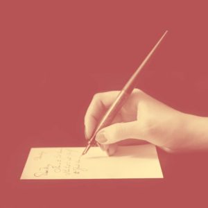 A rustic-looking drawing of a hand holding a pencil to a piece of paper.